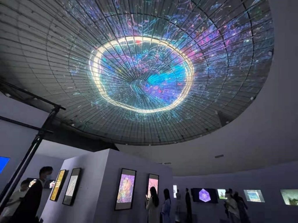 lit dome ceiling with view of screen displays on walls
